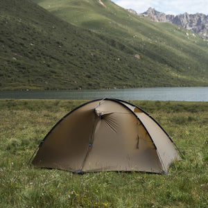 End view of a brown TFS Stars 2 Pro at a grassy lakeside campsite.