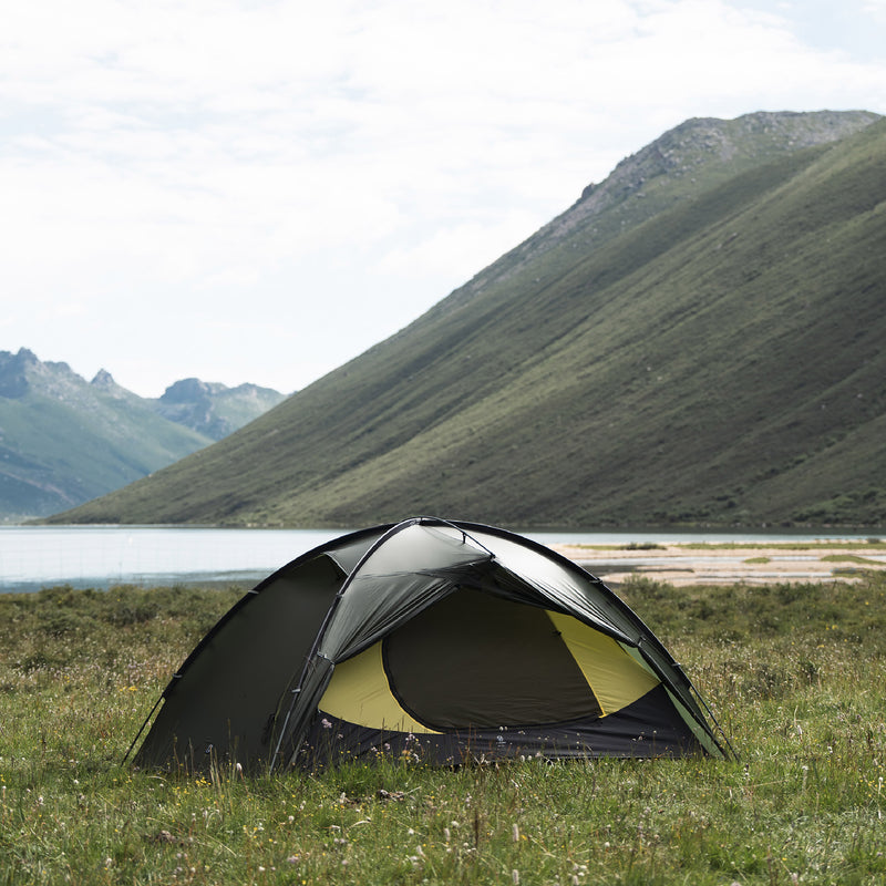 Pine green TFS Stars 2 Pro beside a mountain lake, with the vestibule open to reveal the inner tent.